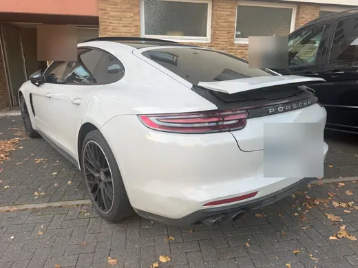 Hellgrauer Porsche Panamera von hinten links auf einem Parkplatz in Gießen, Kennzeichen unkenntlich