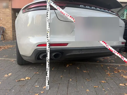 Heck eines Porsche Panamera mit Messlatte und Markierungsband zur Dokumentation der Anstoßhöhe