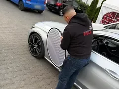 FELZ-Sachverständiger prüft die Fahrzeugseite mit einer Reflektortafel