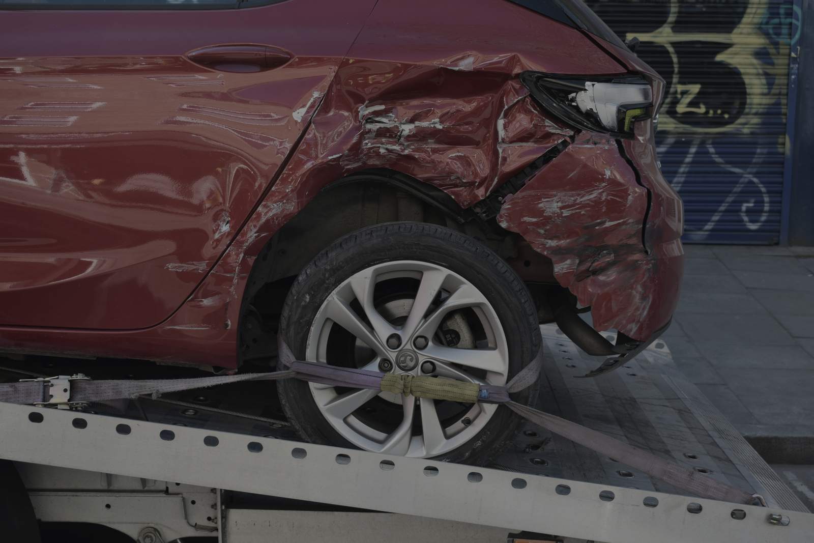 Roter Pkw mit Heckschaden auf dem Abschleppwagen